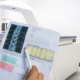 Front view of a technician looking at DXA scan results with machine in the background