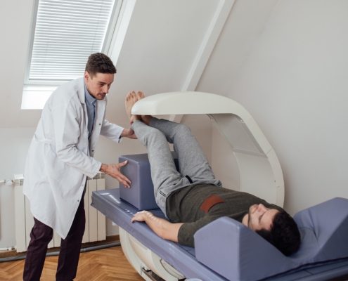 Side view of physician and patient doing a bone scan with DEXA machine