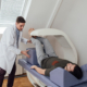 Side view of physician and patient doing a bone scan with DEXA machine