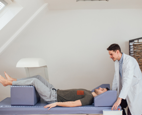 Side view of doctor with patient lying on DXA machine