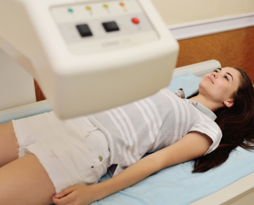Side view of young woman on dxa scanner table