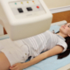 Side view of young woman on dxa scanner table