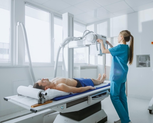 Nurse using xray machine on patient