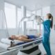 Nurse using xray machine on patient
